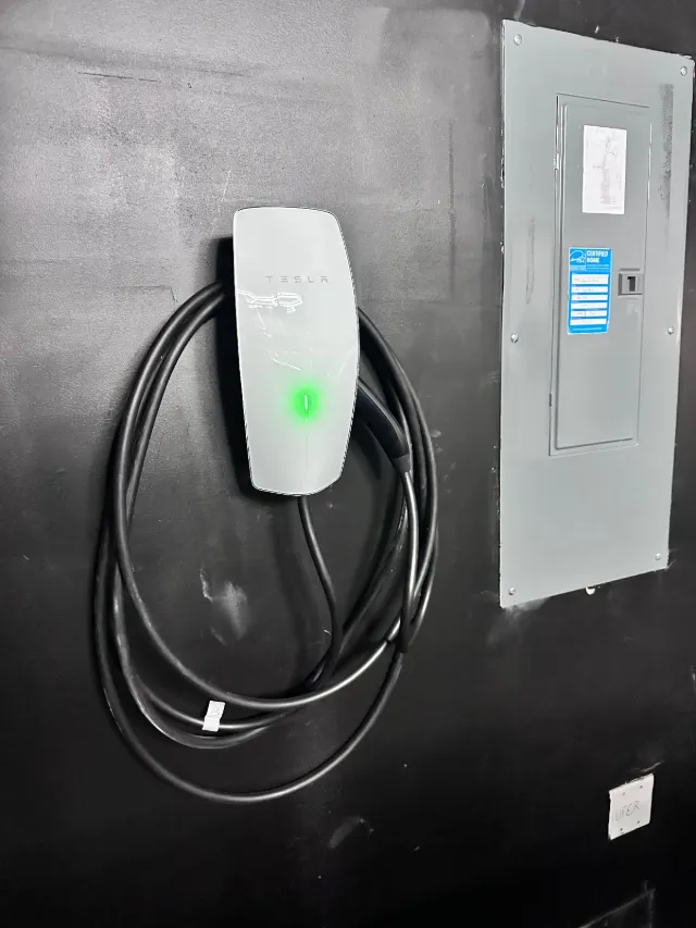 Wall-mounted EV charger next to an electrical panel