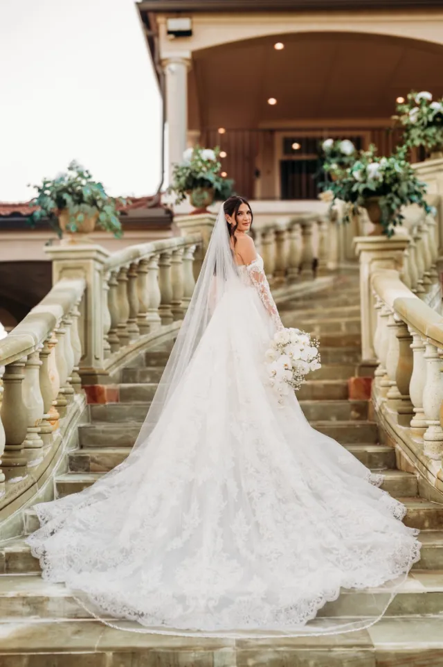 Bride in a long veil on a stone staircase